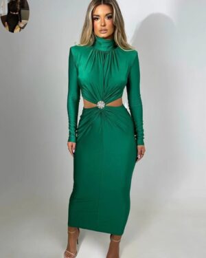 Woman wearing an emerald green long sleeve midi dress with a high neckline, gathered front, waist cutouts, and jeweled center brooch.