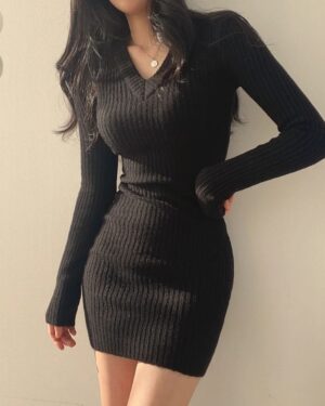 Woman wearing a black curve-hugging ribbed knit mini dress with a V-neckline and long sleeves.