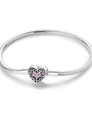 Silver filigree heart charm bracelet with intricate scrollwork, pink crystal heart centerpiece, and polished snake chain design.