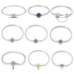 Collection of silver snake chain charm bracelets featuring heart, flower, butterfly, moon, star and colourful decorative clasp designs.