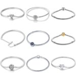 Collection of silver snake chain charm bracelets featuring heart, floral, pavé, gold-tone, blue stone and decorative clasp designs.