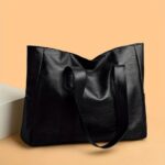 Avery Large Tote Bag-black (3) Black Avery Large Tote Bag shown from the back with long shoulder straps, spacious body and soft textured finish