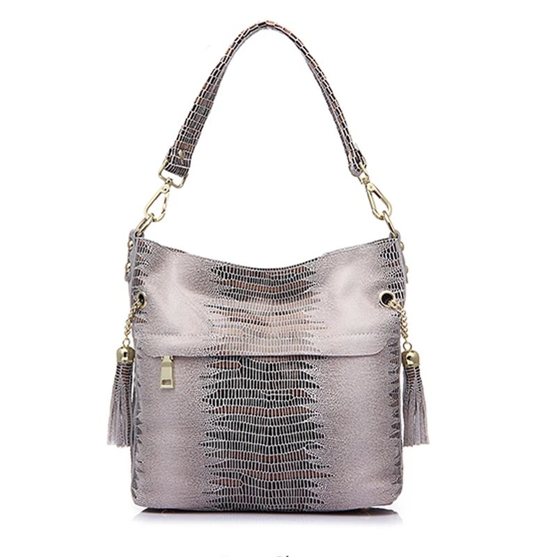 Beige alligator embossed bucket bag for women with shoulder handle, front zipper pocket, tassel accents, and gold tone hardware