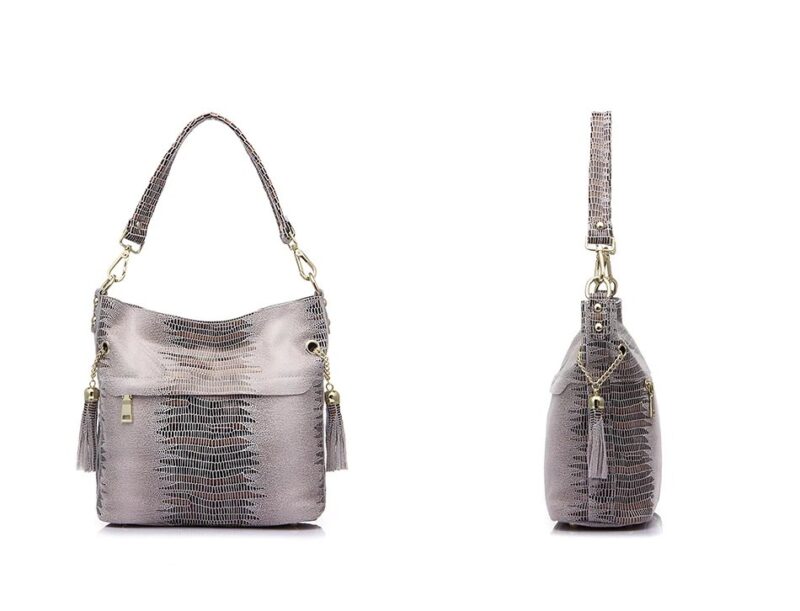 Beige alligator embossed shoulder bucket bag shown from the front and side with tassel accents and detachable handle