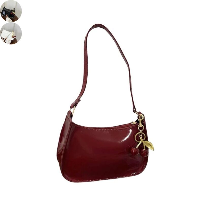 Burgundy red patent shoulder bag with glossy finish, long strap, gold hardware and decorative red cherry charm