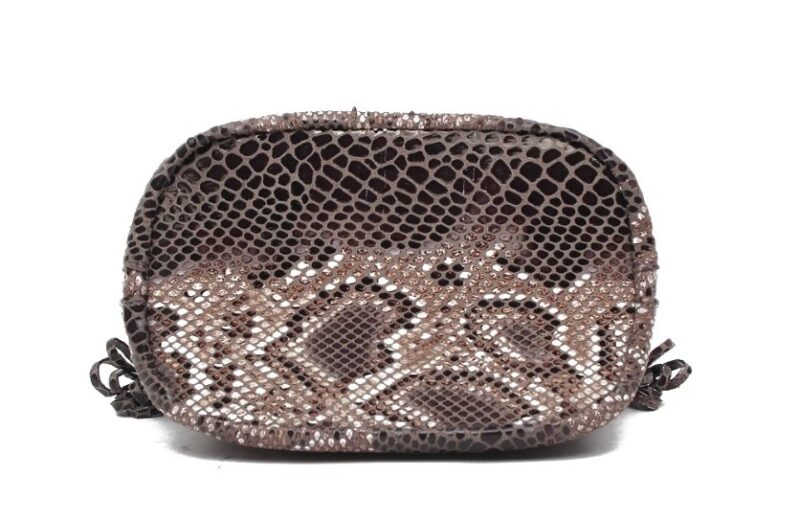 Bottom view of brown Cobra Snake Print bucket bag showing glossy snakeskin pattern and structured oval base