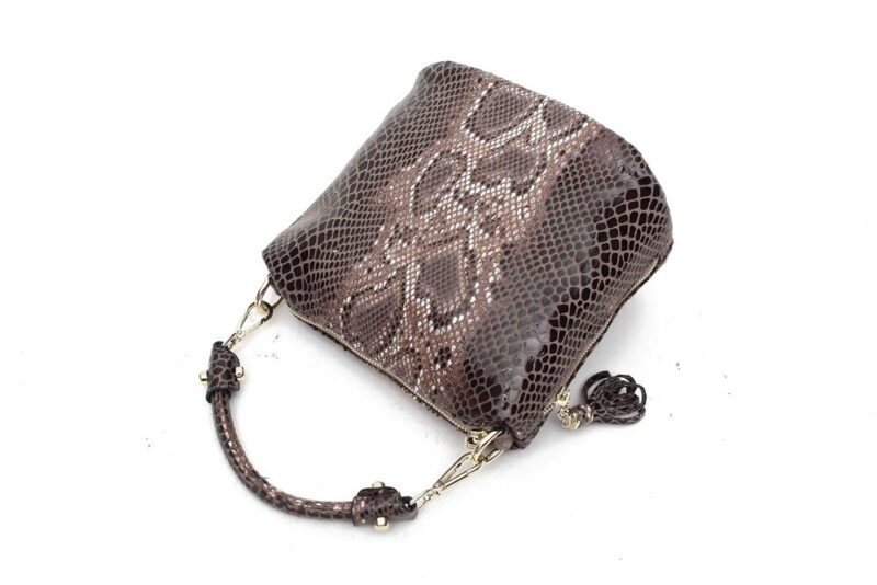 Angled view of brown Cobra Snake Print bucket bag with glossy snakeskin finish, top handle, gold tone hardware and side tassel