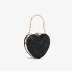 Cupid Rhinestone Heart Clutch (11) Angled side view of black rhinestone heart clutch bag with gold metal frame, crystal clasp and top handle