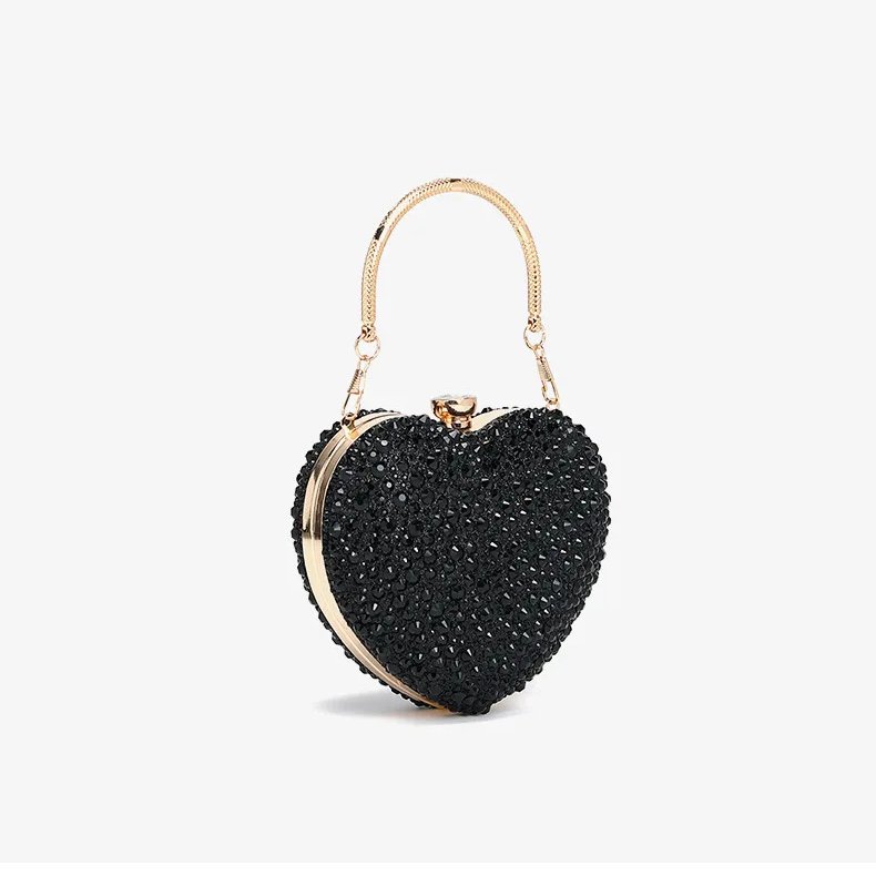 Angled side view of black rhinestone heart clutch bag with gold metal frame, crystal clasp and top handle
