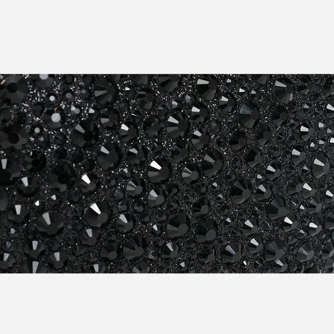 Close-up of sparkling black rhinestone embellishments on heart shaped evening clutch bag