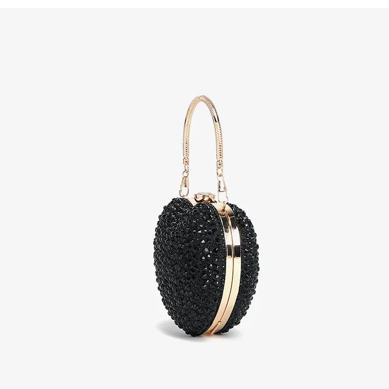 Side view of black rhinestone heart clutch bag showing gold metal frame, structured shape and top handle