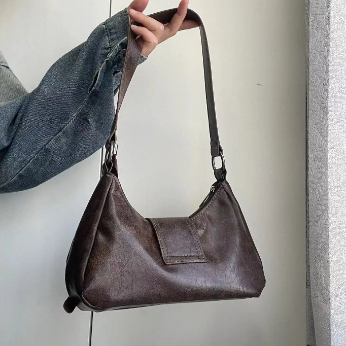 Back view of brown Dalton Retro Buckle Shoulder Bag with smooth vintage-style finish, curved shape and long shoulder strap