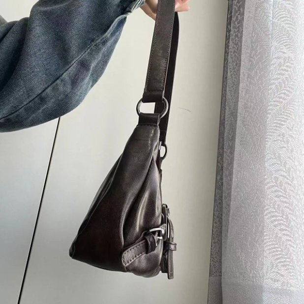 Side view of brown Dalton Retro Buckle Shoulder Bag showing its slim profile, long shoulder strap and silver-tone hardware