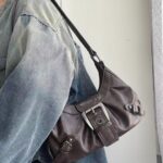 Brown Dalton Retro Buckle Shoulder Bag worn over the shoulder with vintage finish, long strap and silver-tone statement buckle