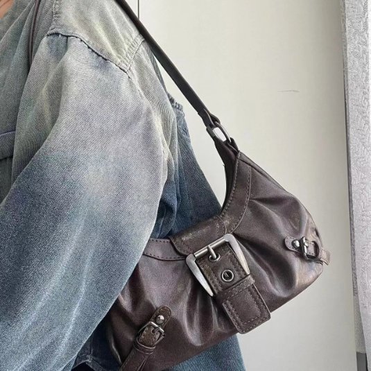 Brown Dalton Retro Buckle Shoulder Bag worn over the shoulder with vintage finish, long strap and silver-tone statement buckle
