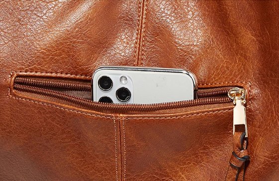 Close-up of brown Delaney Large Hobo Bag exterior zipper pocket holding a smartphone, highlighting convenient storage and gold-tone zipper hardware
