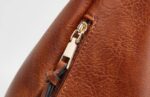 Delaney Large Hobo Bag-brown (11) Detailed close-up of brown Delaney Large Hobo Bag showing gold-tone zipper pull, decorative leather-look tassel and textured stitching