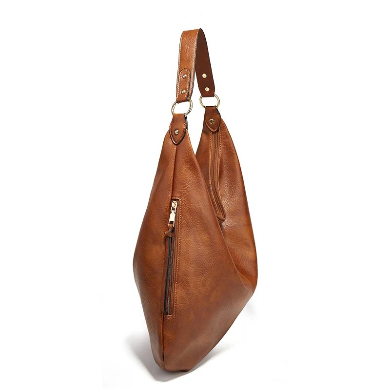 Side view of brown Delaney Large Hobo Bag highlighting its slim profile, vertical zipper pocket, textured exterior and gold-tone shoulder strap attachments