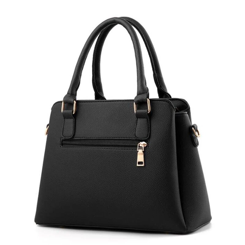 Back view of black Delphine Tassel Charm handbag with double top handles, textured finish and exterior zip pocket