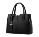 Angled front view of black structured satchel bag with textured finish, double handles and metal hardware