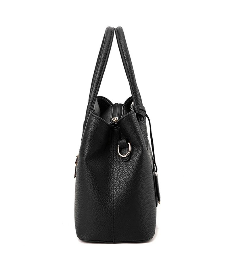 Side view of black textured top handle satchel bag showing structured depth and metal shoulder strap ring