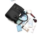 Black structured satchel bag displayed with tablet, phone, wallet, cosmetics and other everyday essentials