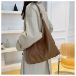Coffee brown Hollis Slouchy Tote Bag worn over the shoulder, showing its roomy slouchy shape and long adjustable strap