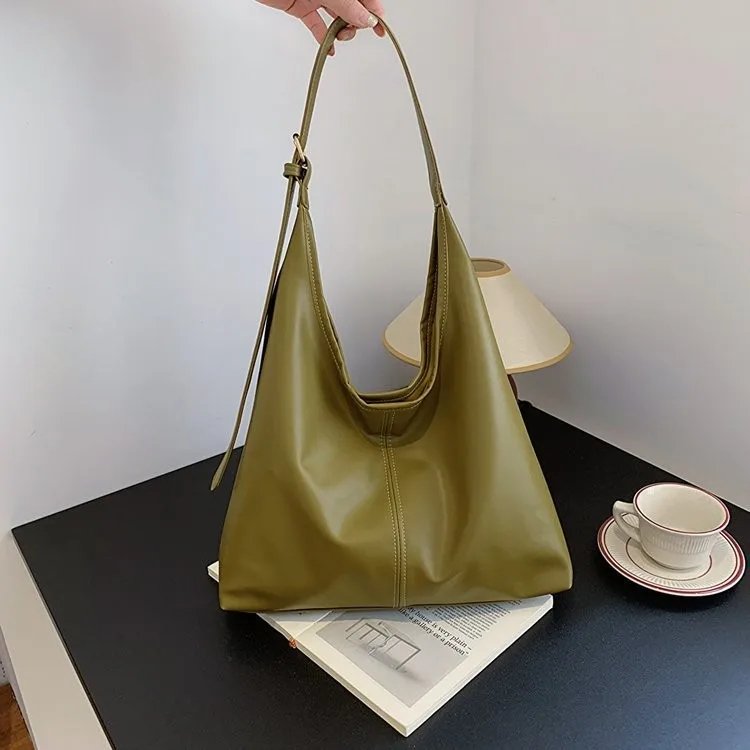 Olive green Hollis Slouchy Tote Bag held by the strap, showing its roomy relaxed shape, smooth finish and centre seam detail