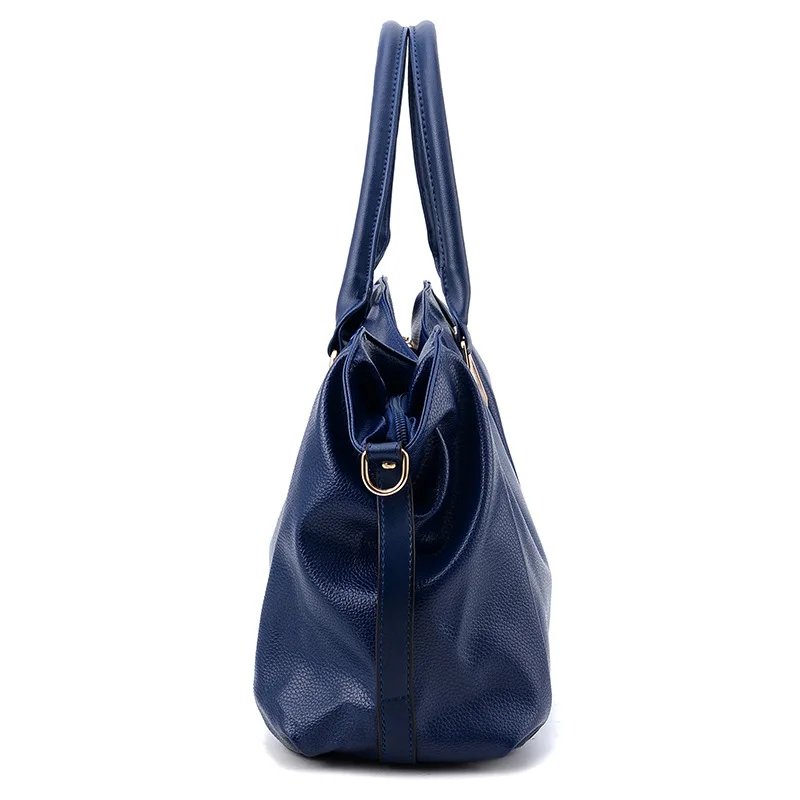 Side view of blue Linden soft hobo satchel bag showing structured base, double handles and shoulder strap attachment