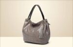 Mamba Snake Embossed Hobo Bag (5) Beige snake embossed hobo handbag for women with double black handles, slouchy shape, tassel charm, and gold tone hardware