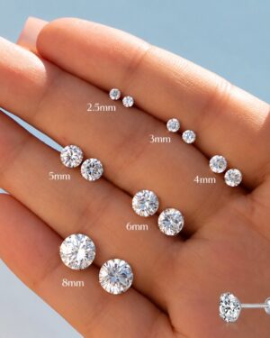 Noelle ball back CZ stud earrings in 2.5mm, 3mm, 4mm, 5mm, 6mm and 8mm sizes displayed on a hand with sparkling round cubic zirconia stones.