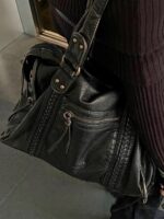 Reese Vintage Washed Shoulder Bag (1) Black Reese Vintage Washed Shoulder Bag with distressed leather-look texture, braided detailing, gold-tone hardware and front zipper pocket worn over the shoulder