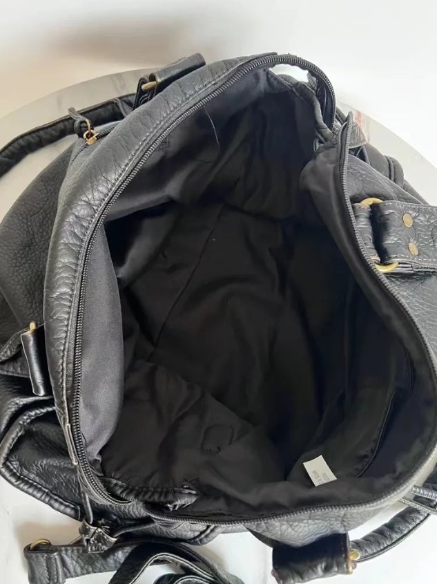 Open black Reese Vintage Washed Shoulder Bag revealing spacious fabric-lined main compartment, zippered opening and interior storage pockets