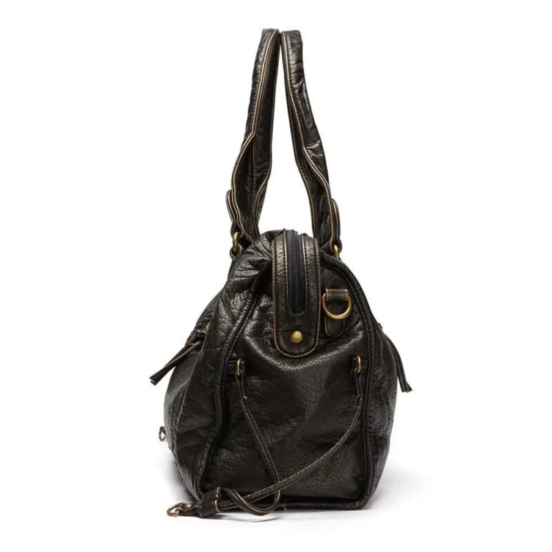 Side profile of black Reese Vintage Washed Shoulder Bag showing rounded shape, top zipper closure, reinforced handles and adjustable shoulder strap attachments