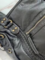 Reese Vintage Washed Shoulder Bag (6) Detailed close-up of black Reese Vintage Washed Shoulder Bag featuring braided trim, textured leather-look finish, gold-tone zipper and reinforced handle attachments