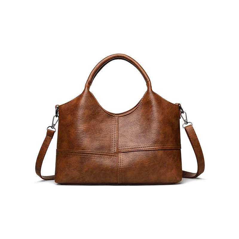 Front view of brown Rowan retro crossbody handbag with top handles, shoulder strap and stitched panel design