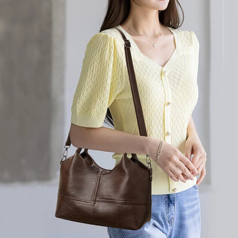 Woman wearing dark brown Rowan retro crossbody bag with adjustable shoulder strap and rounded top handles