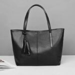 Sable black tassel tote bag with long double shoulder handles, smooth finish and spacious structured design