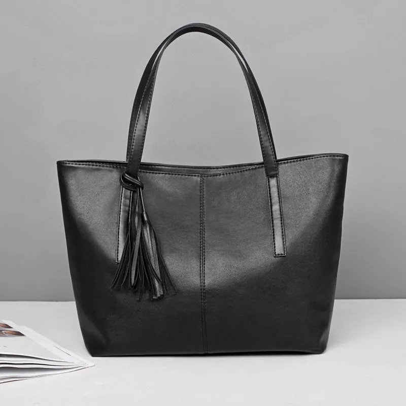 Sable black tassel tote bag with long double shoulder handles, smooth finish and spacious structured design