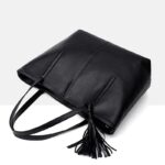 Angled top view of Sable black tassel tote bag showing long handles, structured body and decorative tassel