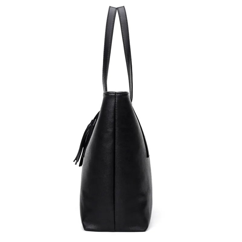Side view of Sable black tassel tote bag showing slim handles, wide base and structured side profile