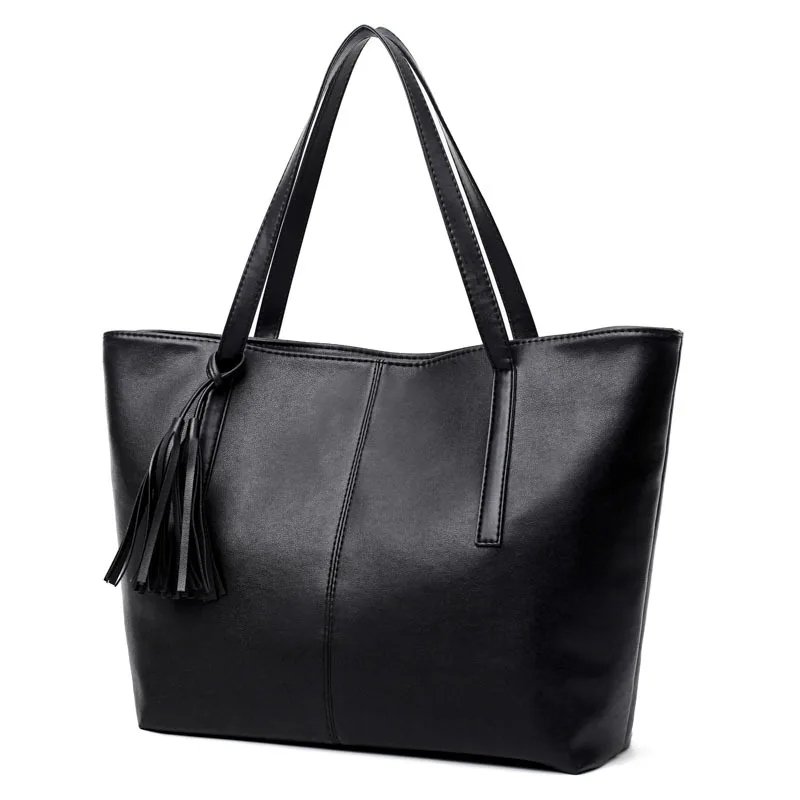 Front angled view of Sable black tassel tote bag with long shoulder handles, centre stitching and decorative tassel