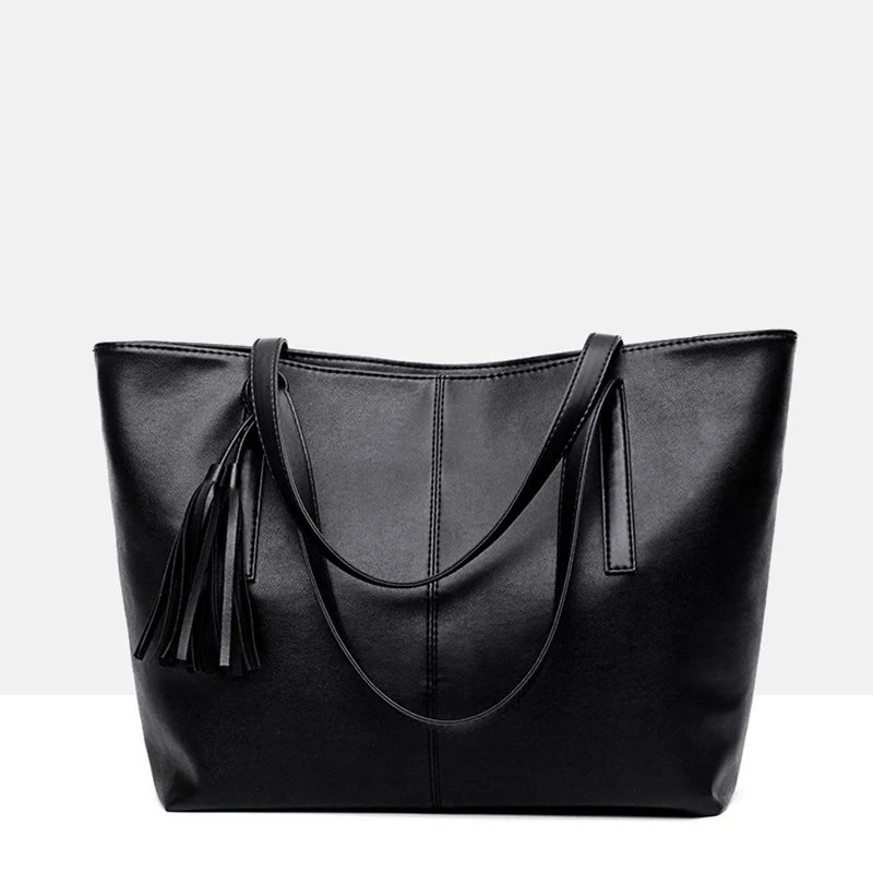 Sable black tassel tote bag with long handles draped across the front and decorative tassel detail