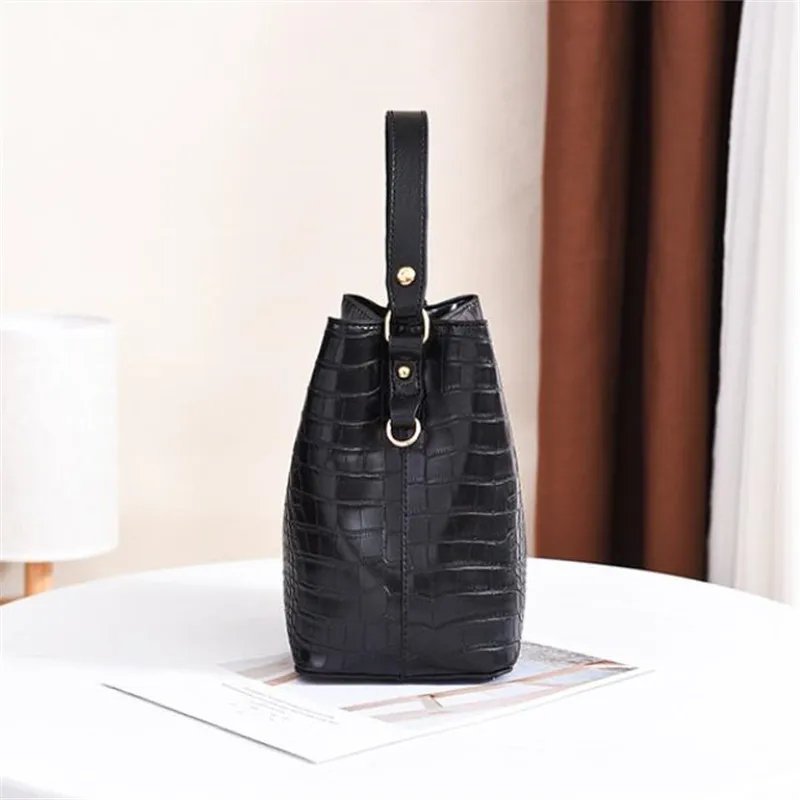 Side view of black Sienna croc pattern bucket bag showing structured base, top handle and shoulder strap ring