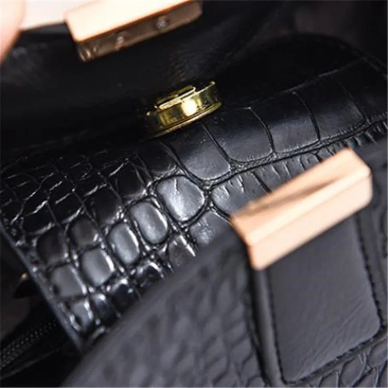 Close-up of black Sienna croc pattern bucket bag magnetic clasp and croc textured exterior