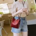 Sienna Croc Pattern Bucket Bag-burgundy (2) Woman wearing burgundy Sienna croc pattern bucket bag crossbody with top handle and long shoulder strap