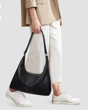 Home - Fashion Trendy Shop Woman carrying black Sutton Hobo Shoulder Bag with adjustable strap, slouchy leather-look design and casual outfit, with black and brown color options