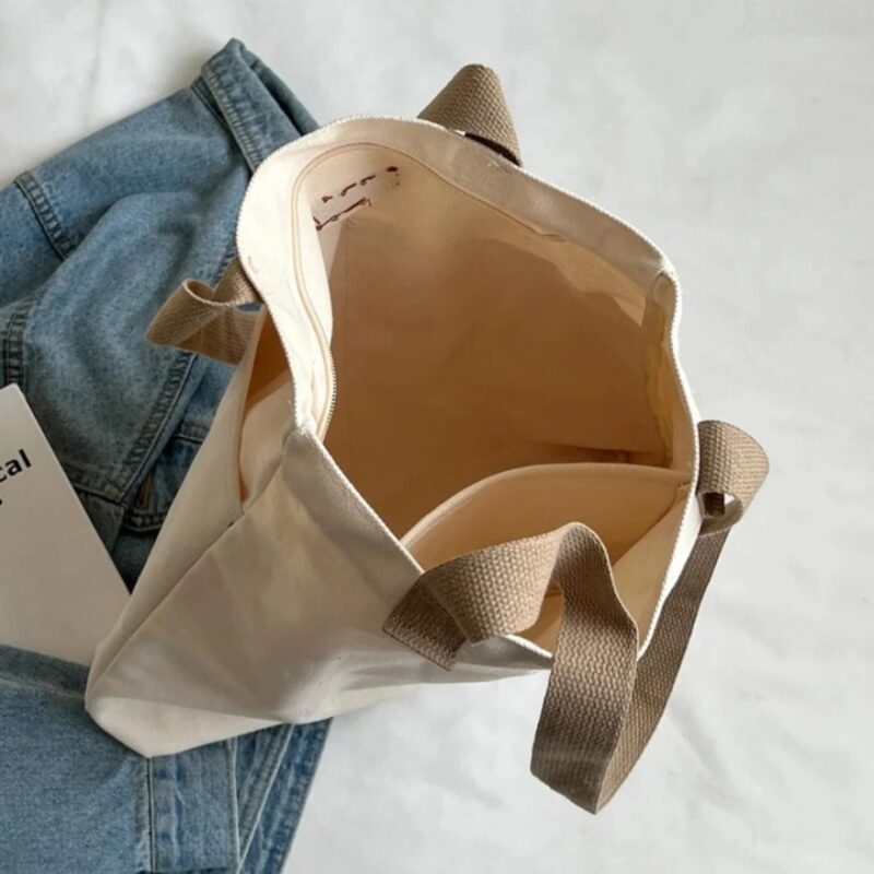 Top view of white Tegan Large Canvas Tote Bag showing roomy main compartment, interior pocket and beige woven shoulder handles