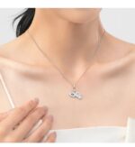 Aziza Hamsa and evil eye CZ necklace worn by a woman with silver chain and sparkling blue eye charms